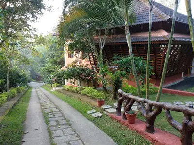 a house with a path next to a building at The Crescent Wayanad Heritage Pool Resort in Sultan Bathery