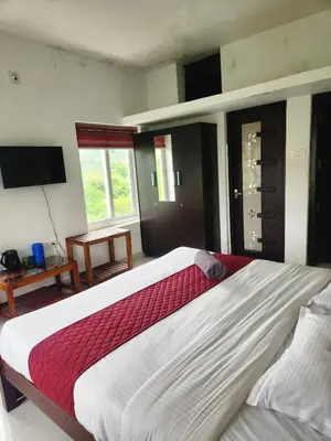 a bedroom with a large bed with a red blanket at White house in Ooty