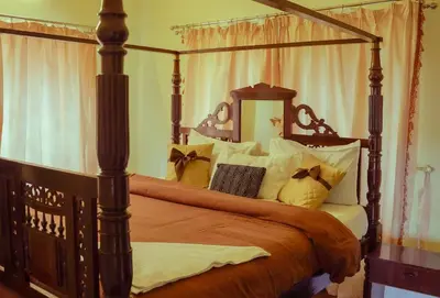 a bedroom with a canopy bed with pillows at Willostays Cloudhill ooty in Ooty