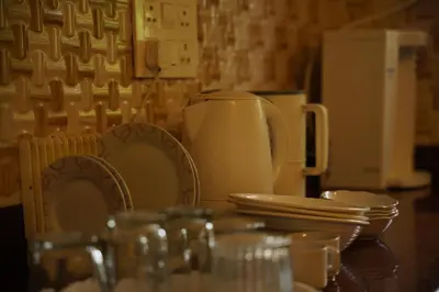 a table with plates and dishes on top of it at Willostays Cloudhill ooty in Ooty