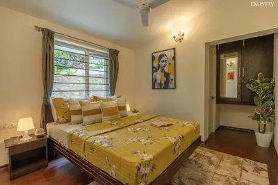 a bedroom with a bed and a window at EKOSTAY - Skyfall Dew Drops in Ooty