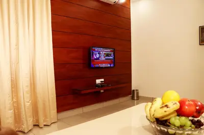 a bowl of fruit and a television in a room at Bhasuri Inn Guruvayoor in Guruvāyūr