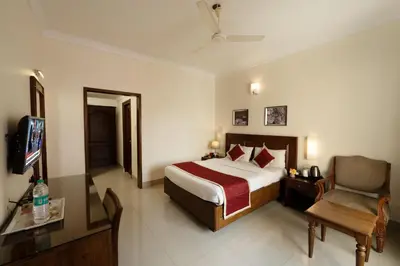a hotel room with a bed and a chair at Bhasuri Inn Guruvayoor in Guruvāyūr