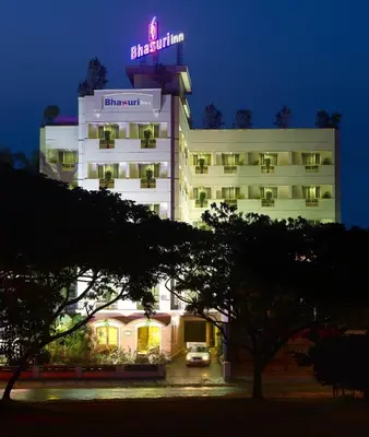a hotel with a neon sign on top of it at Bhasuri Inn Guruvayoor in Guruvāyūr