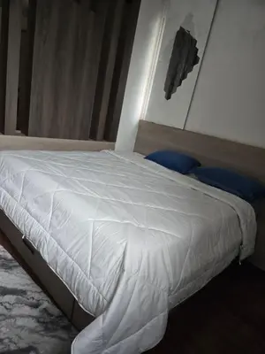 a bedroom with a bed with white sheets at Shan stay Home 2 in Mysore