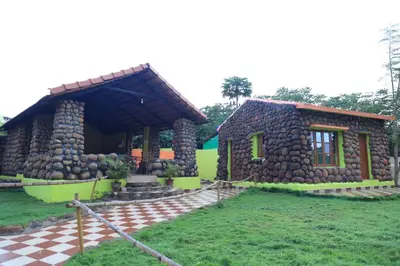 a house with a stone facade and a checkered floor at Vara Farm in Kanakapura