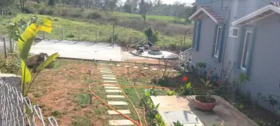 a backyard with a garden and a house at Vara Farm in Kanakapura