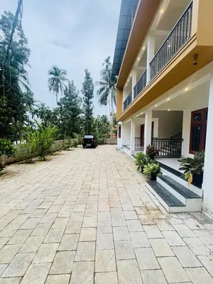 a driveway of a house with a car parked outside at CT HOMESTAY, Omassery in Tāzhekkod