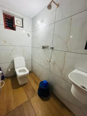 a bathroom with a toilet and a sink at CT HOMESTAY, Omassery in Tāzhekkod