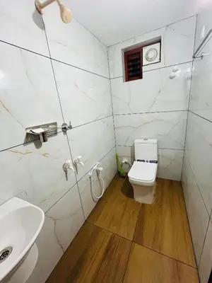 a bathroom with a toilet and a sink at CT HOMESTAY, Omassery in Tāzhekkod