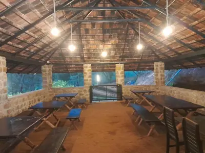 a room with tables and chairs in a building at Deshadan Jungle in Kanthalloor