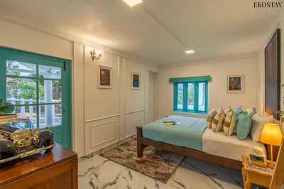 a bedroom with a bed and a desk and a window at EKOSTAY - Casa Del Sol in Ooty