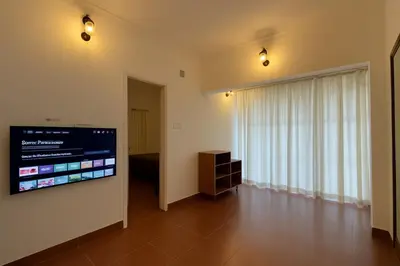 a living room with a flat screen tv on a wall at Country Side Inn in Vayittiri