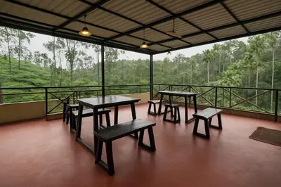 a group of tables and benches on a balcony at Country Side Inn in Vayittiri