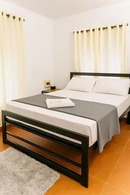 a bedroom with a large bed with white sheets at Country Side Inn in Vayittiri