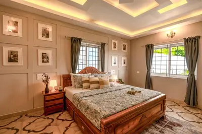 a bedroom with a large bed and two windows at EKOSTAY - Garden Grove Villa in Ooty