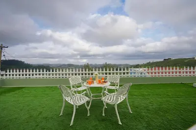 a table and chairs sitting on a lawn at EKOSTAY - Dutch Cottage in Ooty