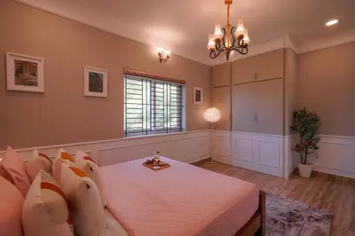 a bedroom with a bed and a chandelier at EKOSTAY - Dutch Cottage in Ooty
