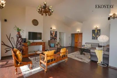 a living room filled with furniture and a chandelier at EKOSTAY - Skyfall Cloud 9 Villa in Ooty