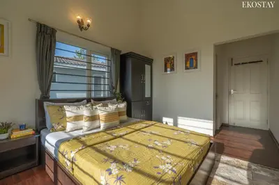 a bedroom with a bed with a yellow comforter at EKOSTAY - Skyfall Cloud 9 Villa in Ooty