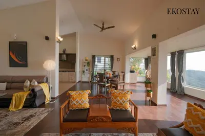 a living room with a couch and a table at EKOSTAY - Skyfall Cloud 9 Villa in Ooty