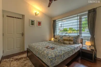 a bedroom with a bed and a large window at EKOSTAY - Skyfall Cloud 9 Villa in Ooty
