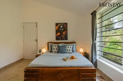 a bedroom with a bed with a teddy bear on it at EKOSTAY - Skyfall Mist Villa in Ooty