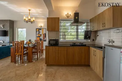 a kitchen with wooden cabinets and a dining room at EKOSTAY - Skyfall Mist Villa in Ooty