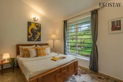 a bedroom with a large bed and a window at EKOSTAY - Skyfall Mist Villa in Ooty
