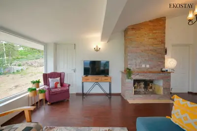 a living room with a fireplace and a tv at EKOSTAY - Skyfall Elysium Villa in Ooty