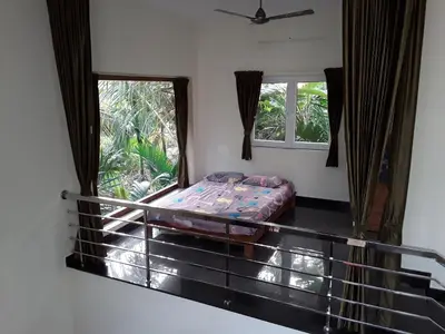 a bed in a room with two windows at SriMahi Farmhouse in Agali