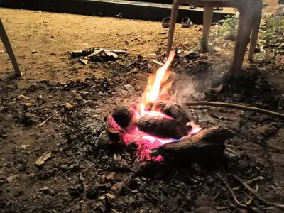 a fire in the dirt with a person standing next to it at SriMahi Farmhouse in Agali