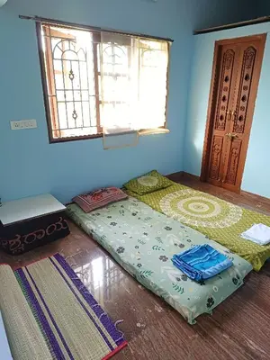 a room with a bed and a window and a bed sidx sidx sidx at Pine Stay in Alāndurai