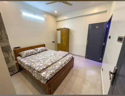a bedroom with a bed and a door in it at Pine Stay in Alāndurai
