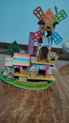 a toy boat with a windmill on a table at Pine Stay in Alāndurai