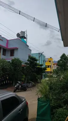 a car parked in a parking lot next to a building at Pine Stay in Alāndurai