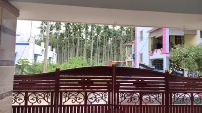 a wooden fence in front of a building at Pine Stay in Alāndurai