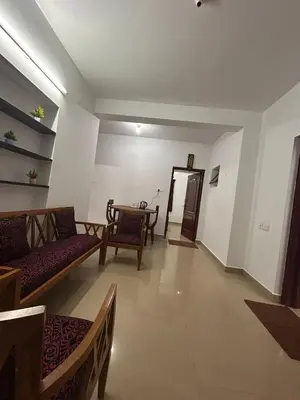 a living room with a couch and a table at Shivvs Leisure Rooms & Villa Ooty in Ooty