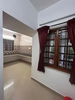 an empty room with a large window with red curtains at Shivvs Leisure Rooms & Villa Ooty in Ooty