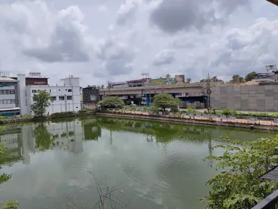 a river in the middle of a city with buildings at Queens INN in Kodungallūr