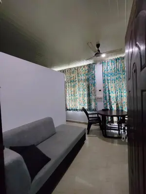 a living room with a couch and a table at Queens INN in Kodungallūr