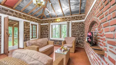 a living room with a brick wall at Zacs Valley Resort & Wellness Retreat Kodaikanal in Kodaikānāl
