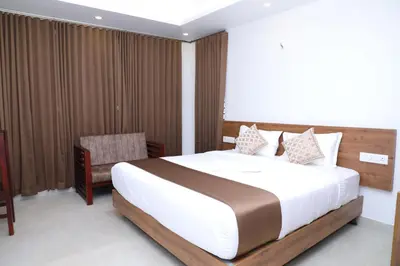 a bedroom with a large bed and a chair at Aura Airport Hotel in Nedumbassery