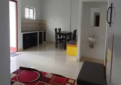 a living room with a table and a sink in it at JJ Homes in Ooty