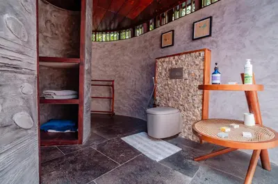 a bathroom with a table and a toilet in a room at Madilina Cottage in Parūr