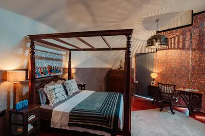 a bedroom with a canopy bed and a desk at Madilina Cottage in Parūr