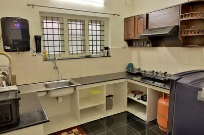 a kitchen with a sink and a counter top at Prithvi Nila Heavens 3 BHK Homestay Ground Floor in Guruvāyūr
