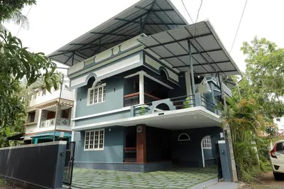 a blue house with a balcony at Akasha Nila Heavens 2 BHK Homestay - Top floor in Guruvāyūr