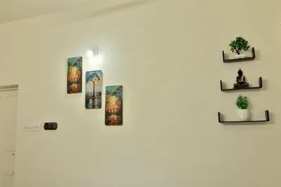 a white wall with four pictures on it at Akasha Nila Heavens 2 BHK Homestay - Top floor in Guruvāyūr