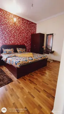 a bedroom with a bed with a red wall at AAK Hills stay villa in Kodaikānāl